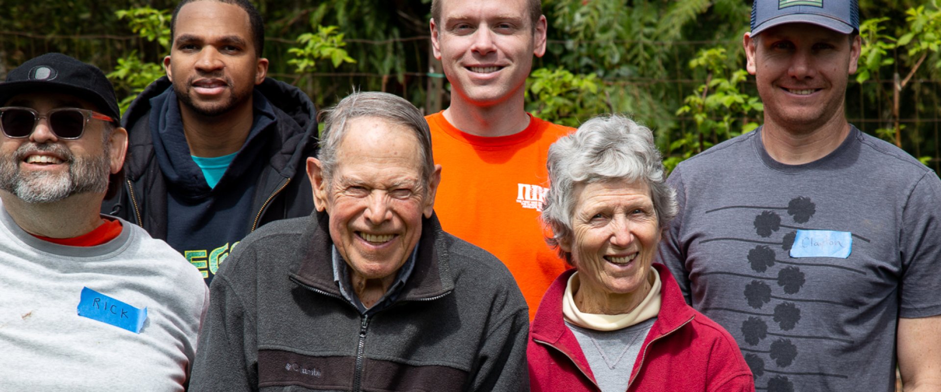 An older couple flanked by several volunteers