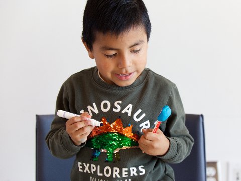 a young boy plays with crafts