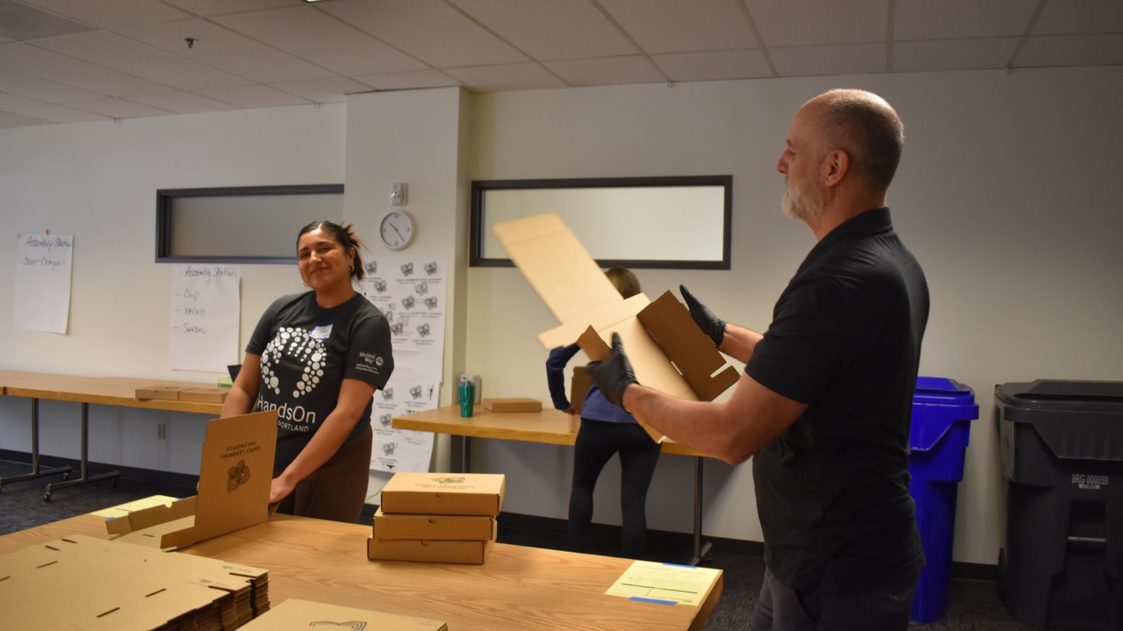 A United Way employee works alongside a volunteer from WaFd building STEM kits.