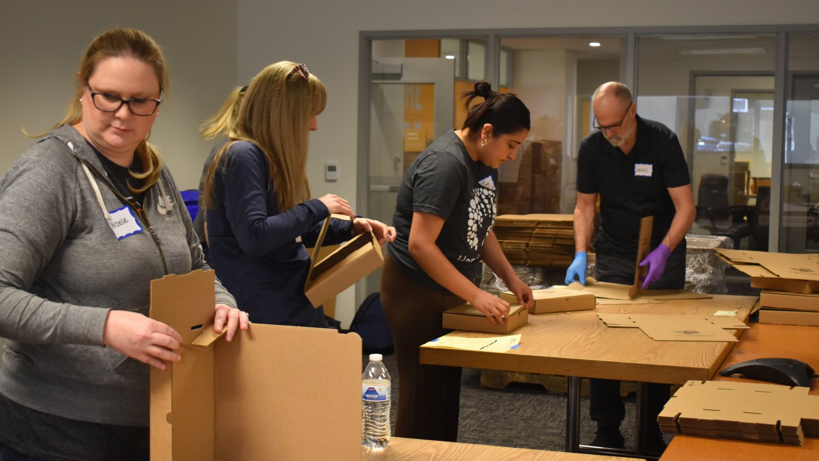 Four volunteers hard at work building STEM kits.