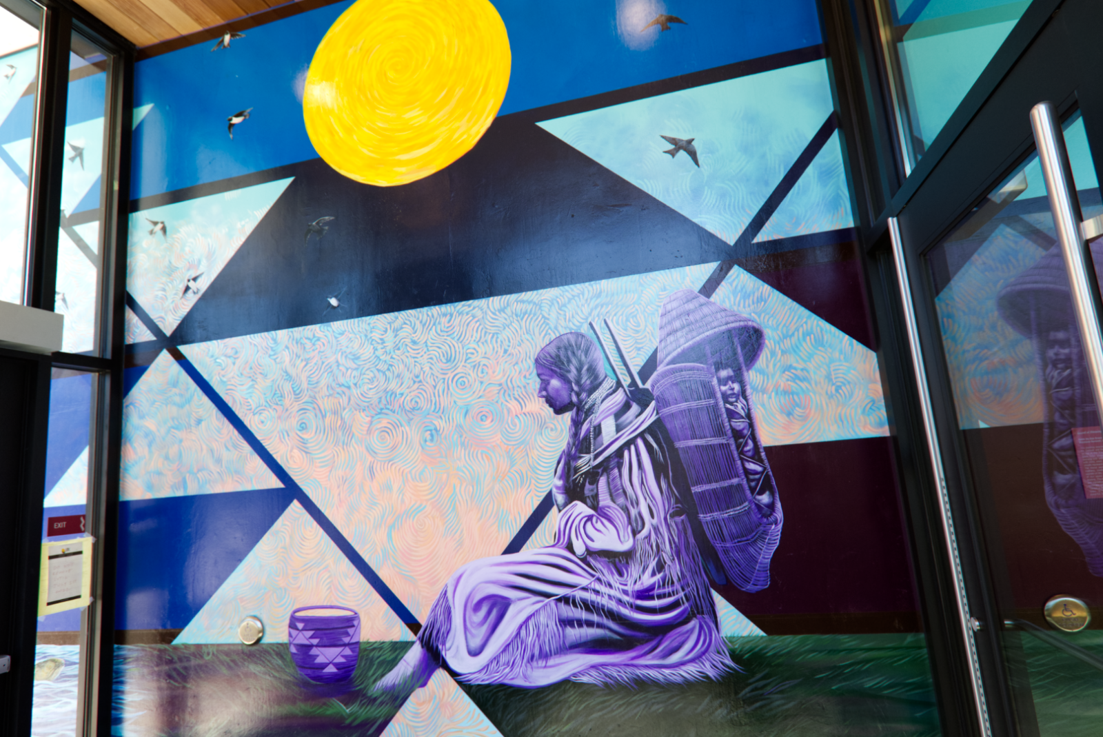 A photo of a mural of a Native woman under a shining moon