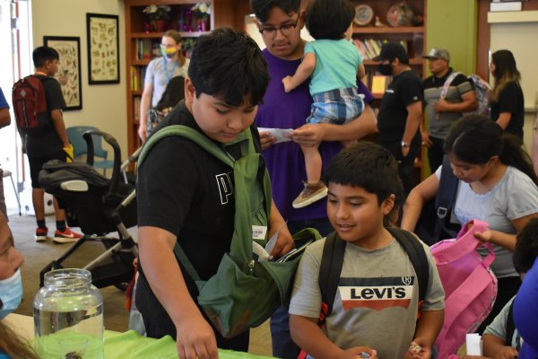 Bienestar residents play educational games to fill their backpacks with school supplies.