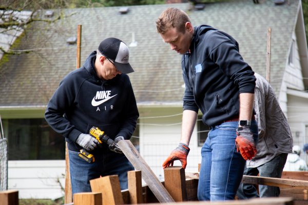 Two men work on a raised garden bed