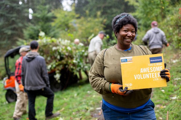 A woman holds a yellow sign outdoors