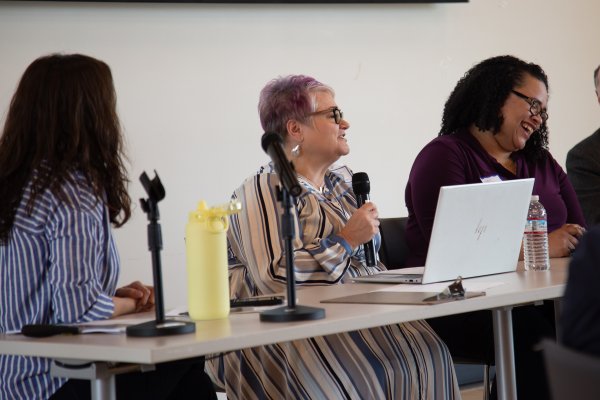 A group of three women at a table talking in a microphone