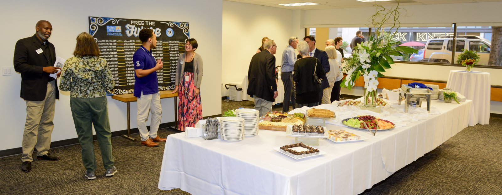 A group of people utilizing our community space with a spread of food on the table.
