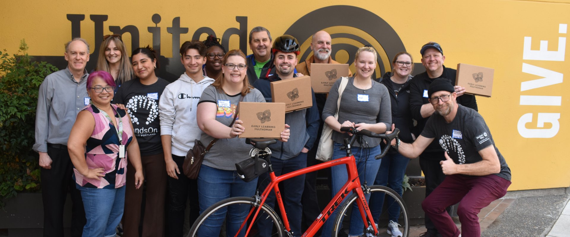 A group of 13 volunteers from WaFd Bank and United Way Staff members pose with completed STEM kits. 