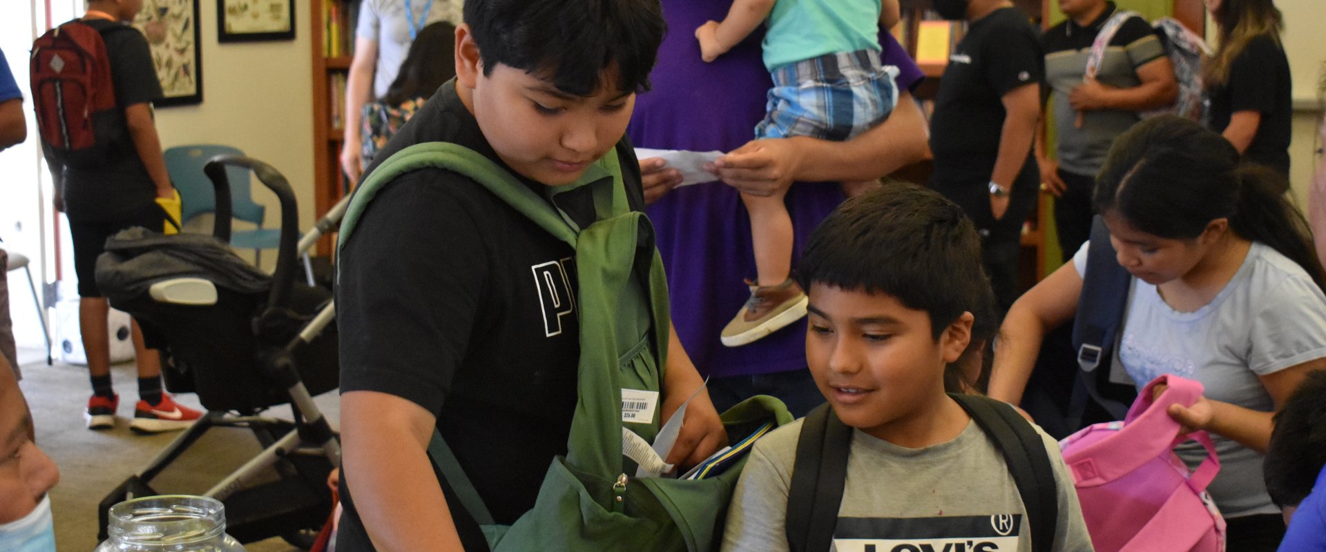 Bienestar residents play educational games to fill their backpacks with school supplies.
