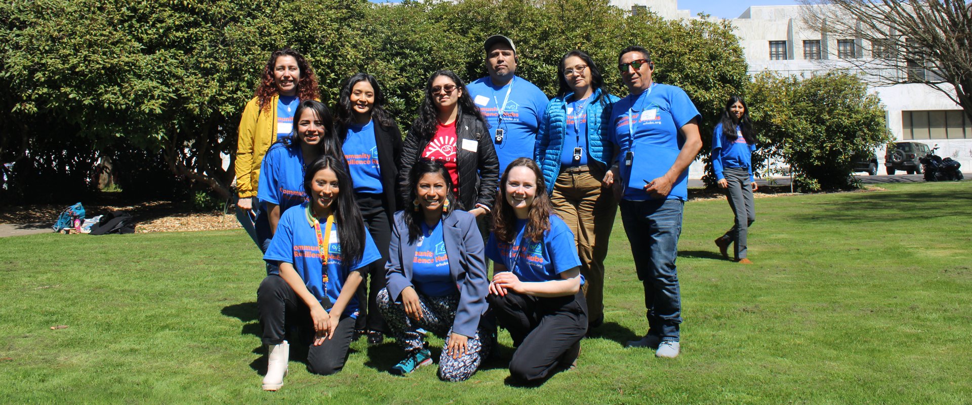 A group of people stand in front of the Oregon State Capitol Building