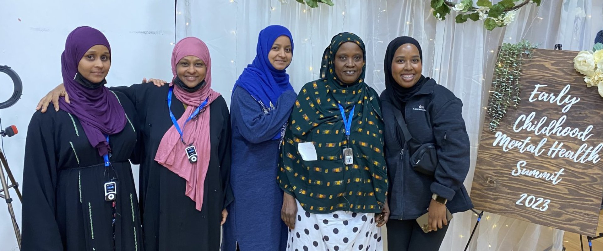 A group of women stand and smile for the camera