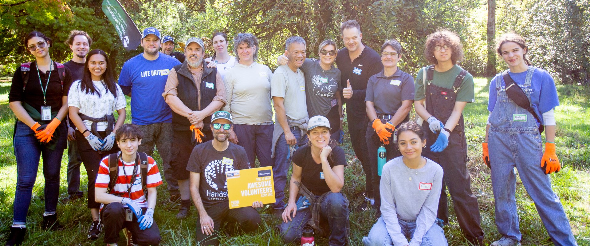 A group of people pose outdoors with sunshine behind them.