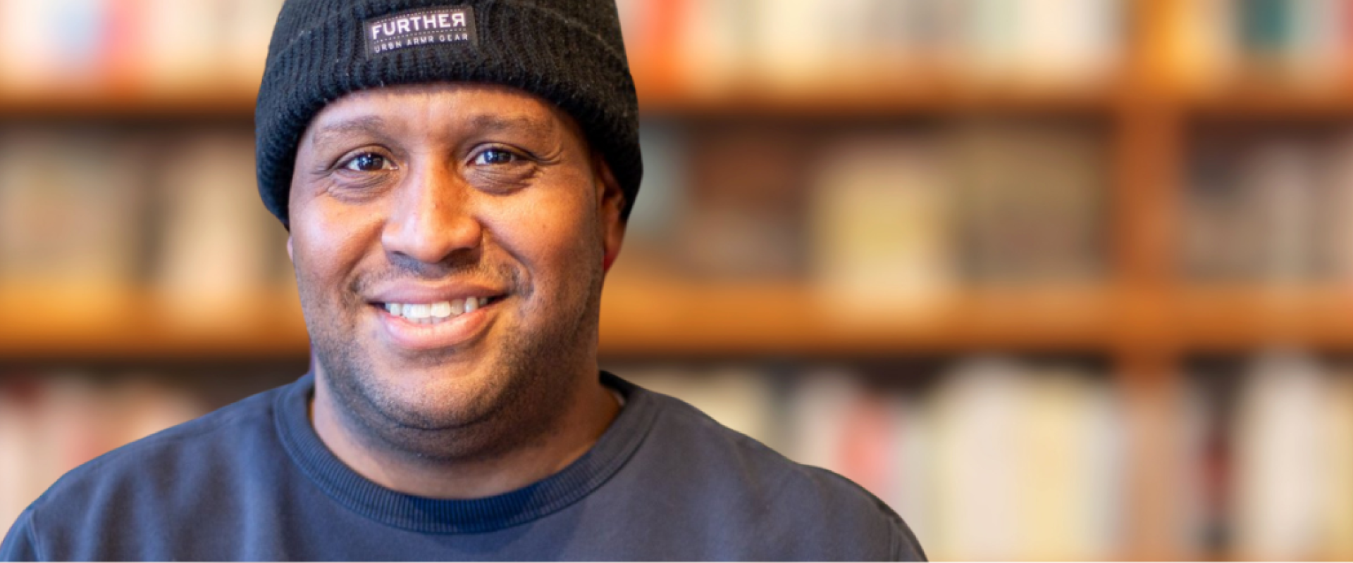 A man smiles for the camera with a blurred background