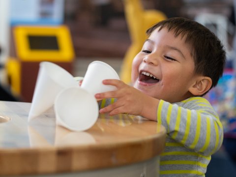A child plays with paper cups