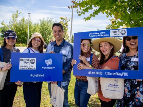 A group of parents smile holding ELM banners