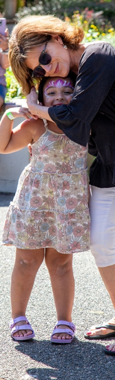 A woman hugs a child who is smiling