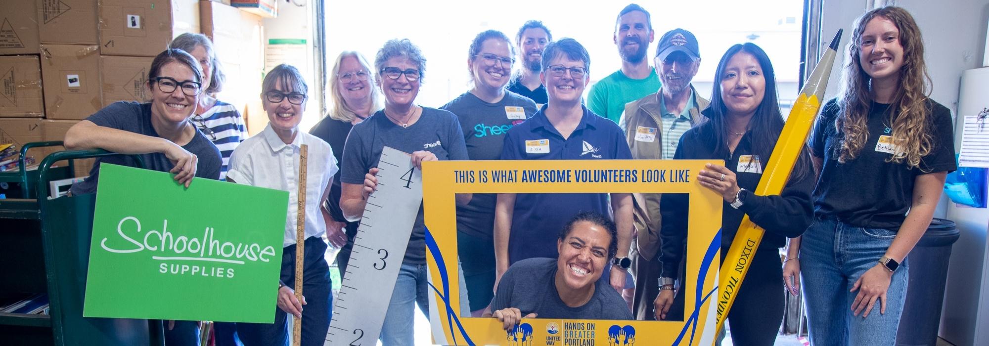 a ghroup of volunteers smiles with signs