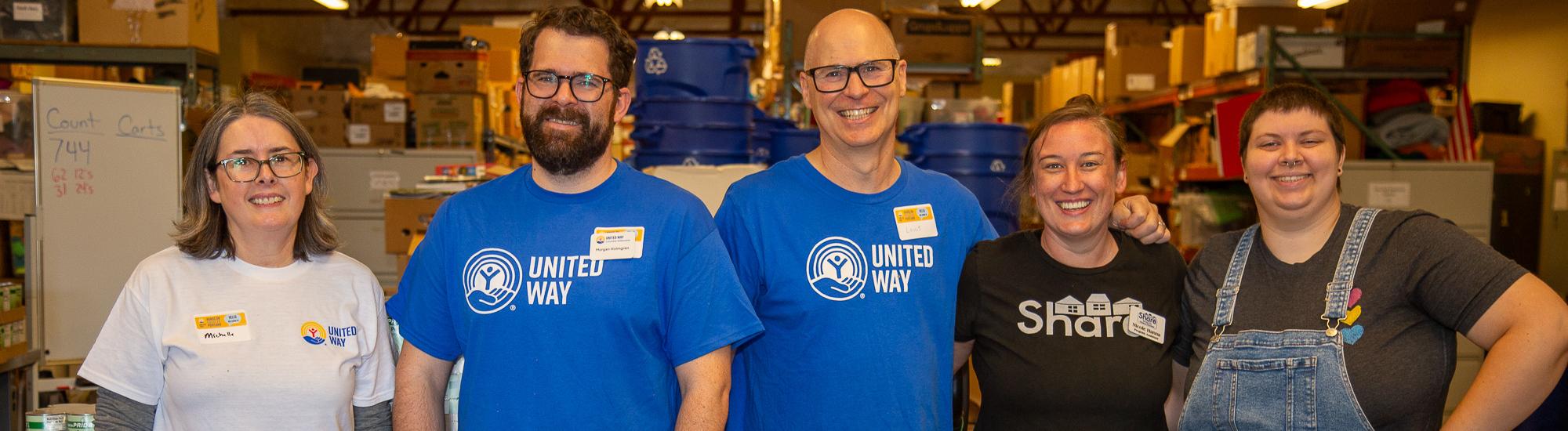 A group of 5 smile for the camera. Several are in United Way branded gear