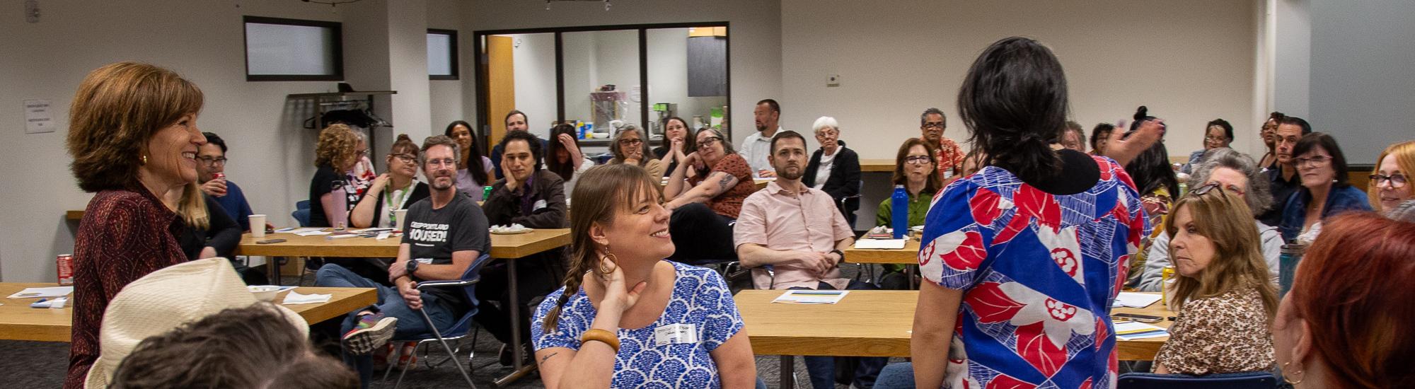 A group of people in a conference room smile