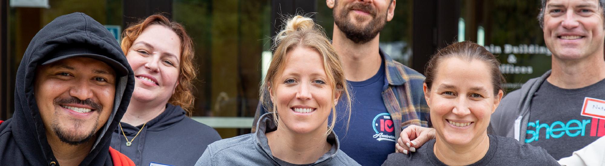 A photo of several people smiling outdoors