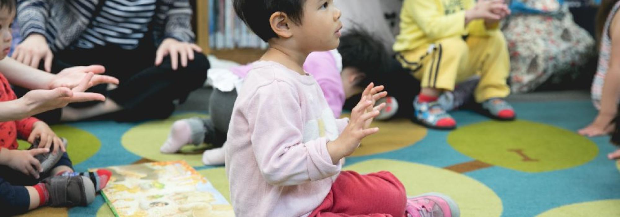 child sitting on floor listening to a story