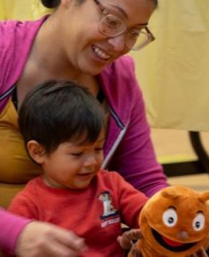 a mom and child play with a insect plushie
