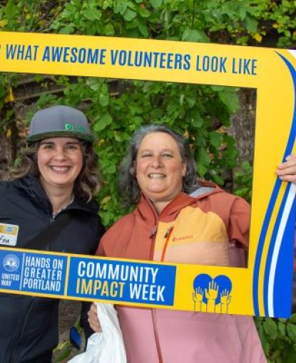 Two volunteers smile