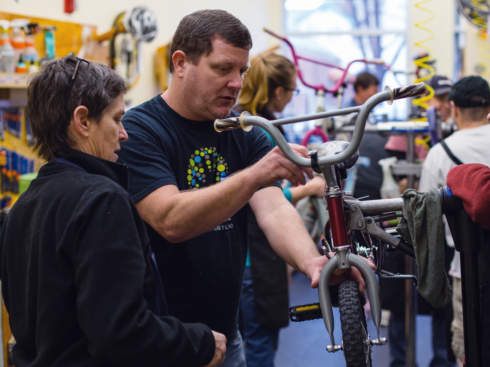 Larry and other volunteers fixing kids’ bikes in a bike shop