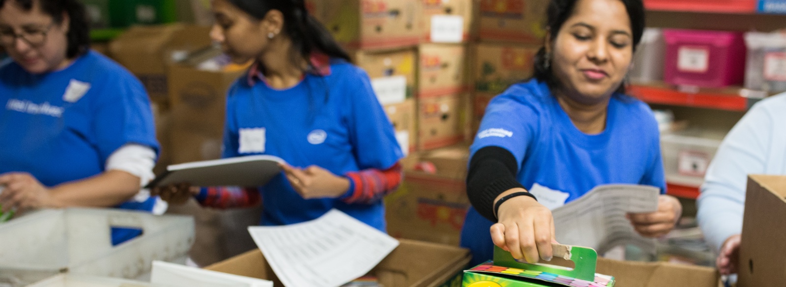 Volunteers sorting school supplies into bins